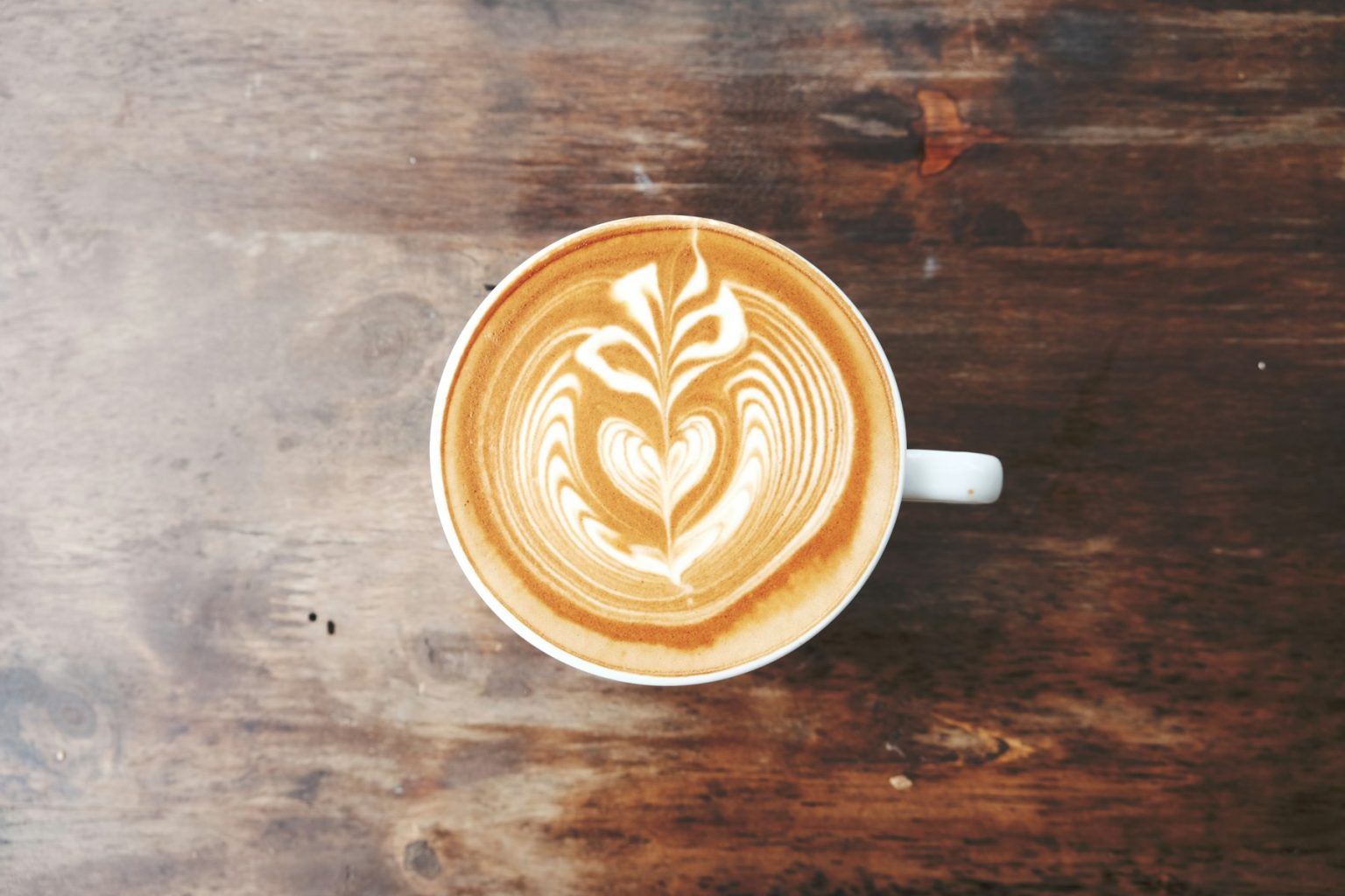 A latte with poured leaf art at the Uppercuts Beverage Bar