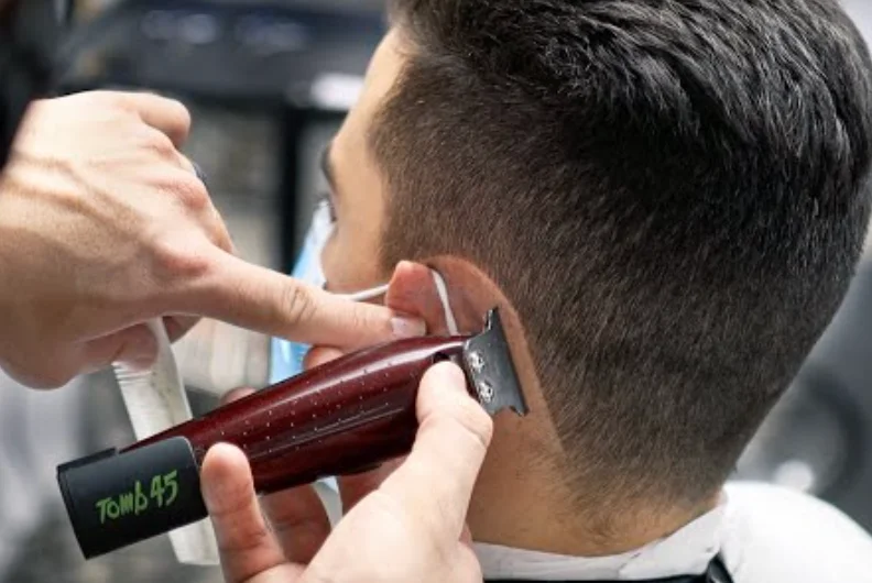 Barber lining up a hairline with clippers