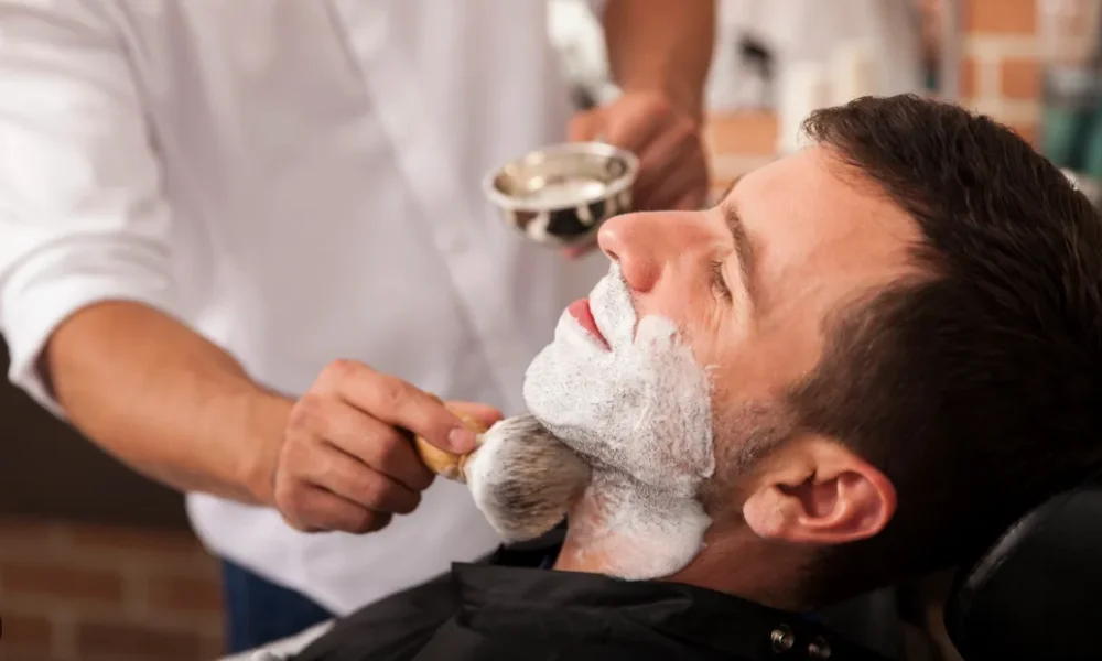 Hot towel being applied before a straight razor shave
